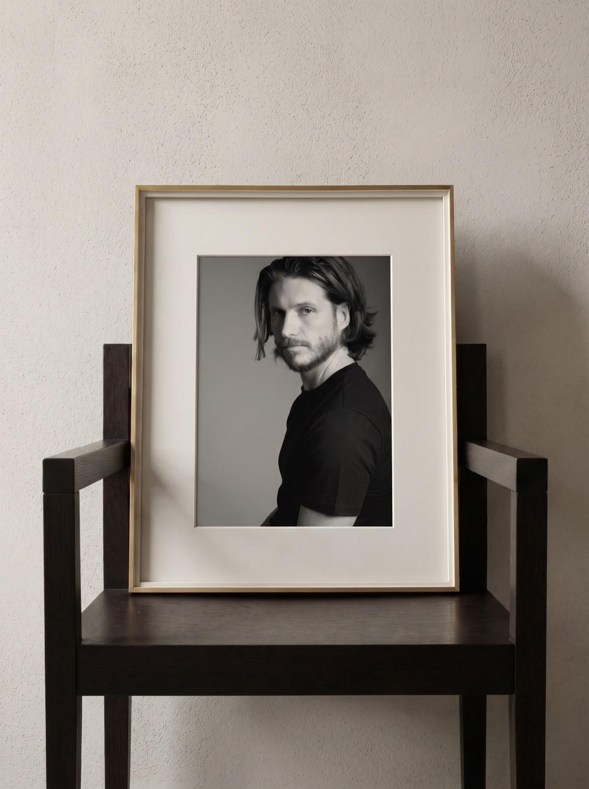 Ritratto Magneti® in cornice oro satinato, appoggiato su una sedia di design